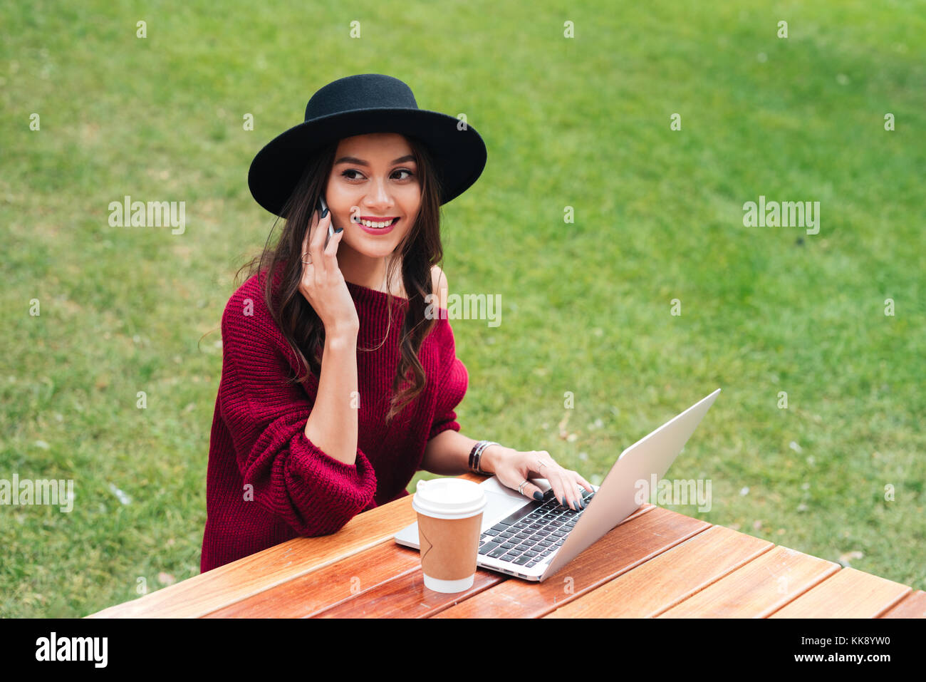 Portrait of a cheerful young asian girl using laptop computer while ...