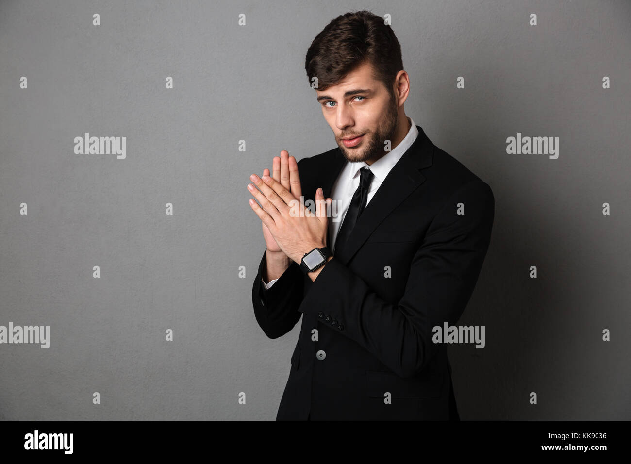 Close-up photo of handsome young man in black suit clap in hands ...