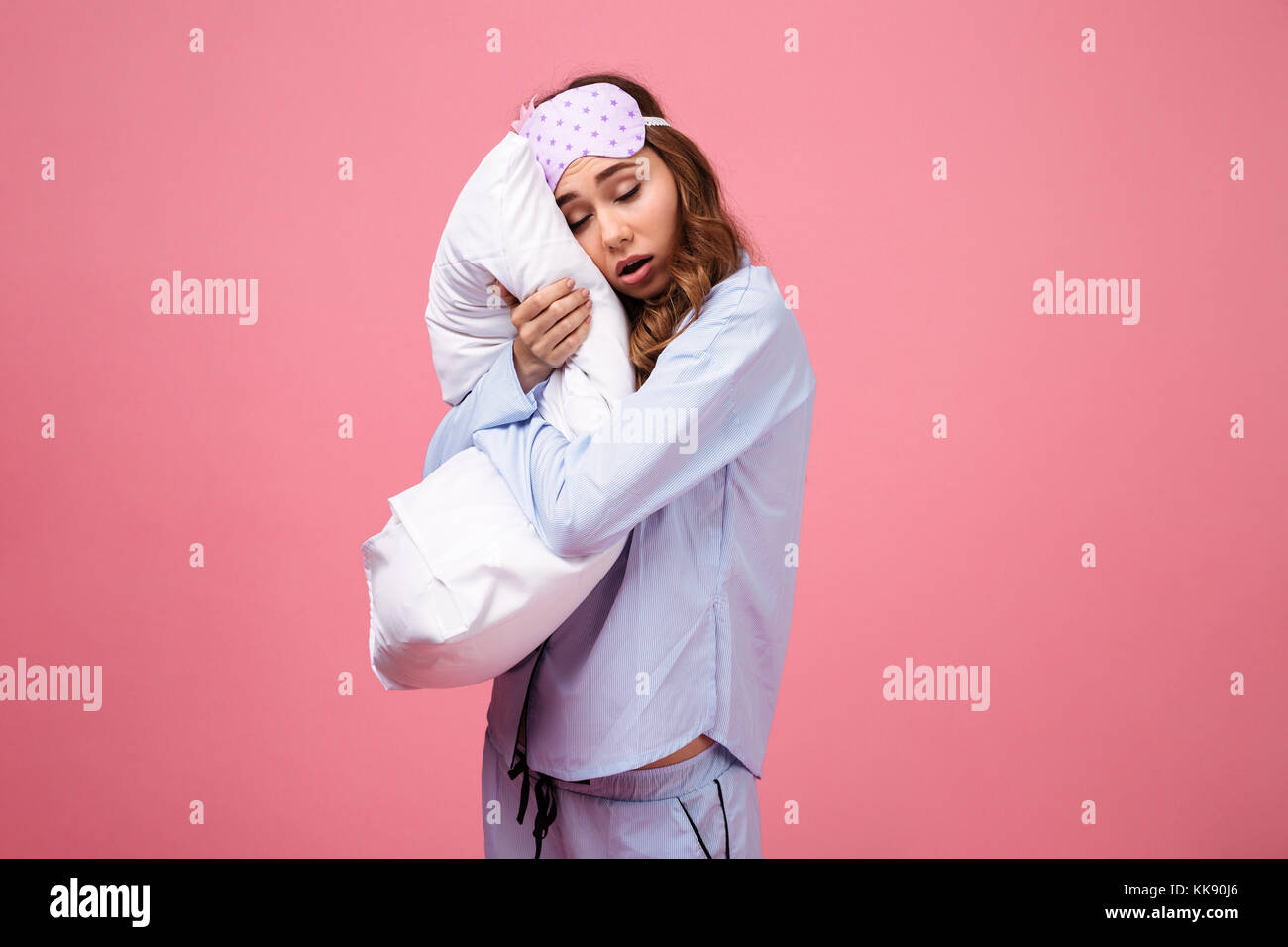 Tired Pyjamas Portrait of a tired pretty girl dressed in pajamas holding pillow and ...