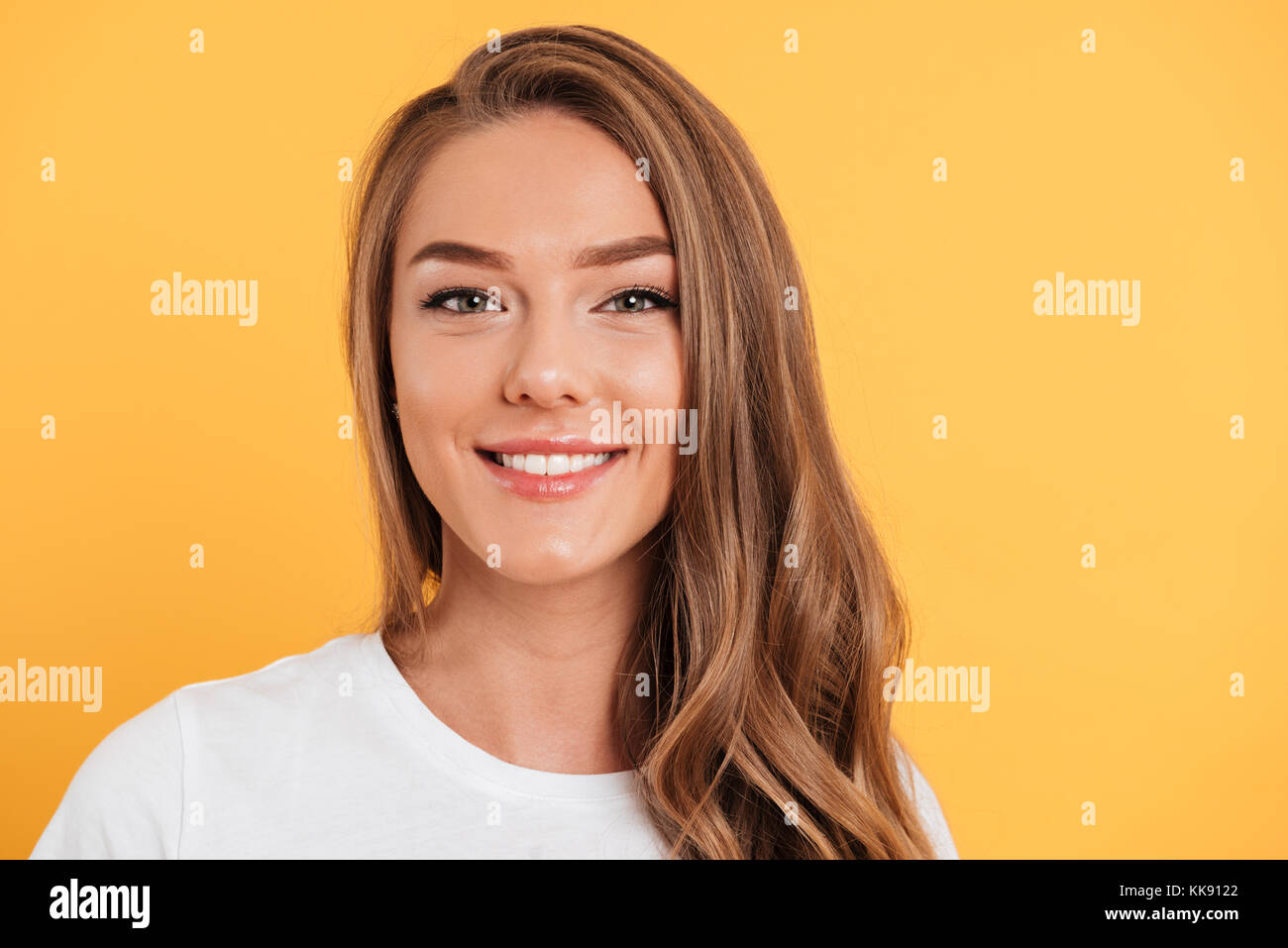 Close up portrait of a young smiling girl with long blond hair looking ...