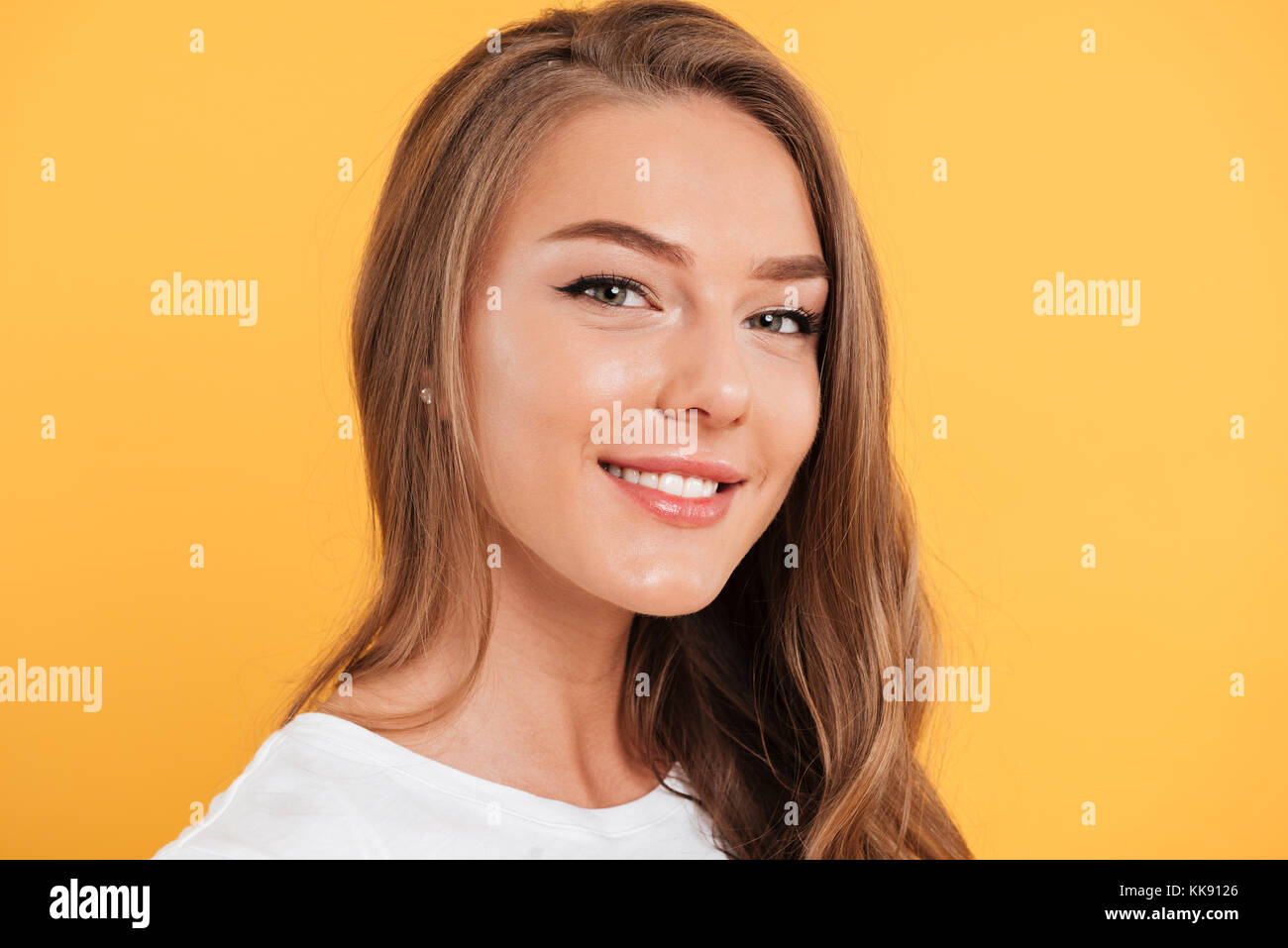 Close up portrait of a pretty smiling girl with long blond hair looking ...