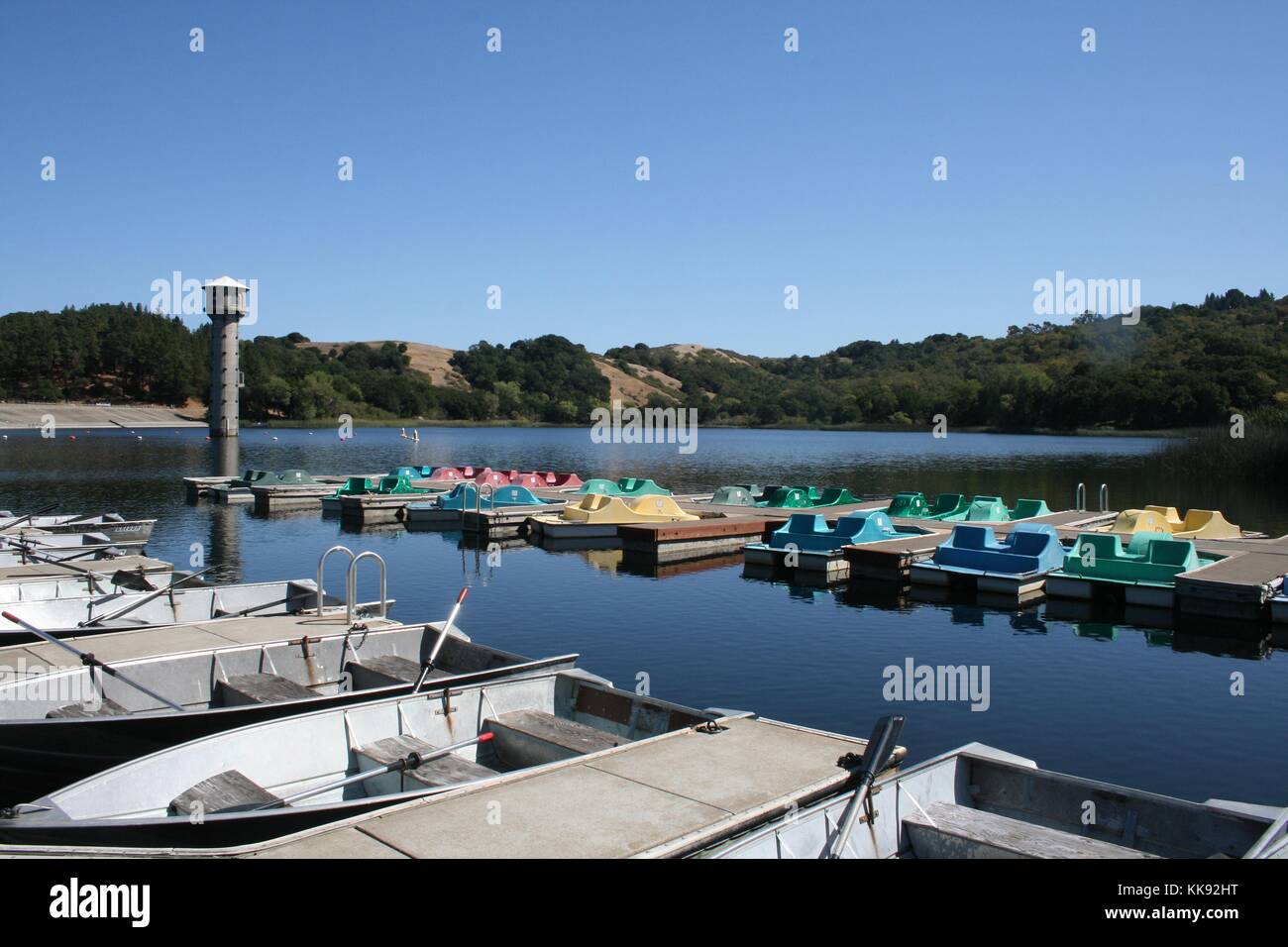 A photograph of docked rowboats and pedal boats at the Layfayette Reservoir, the reservoir is surrounded by nature areas open to the public, the photo was taken during a time where the water levels in the reservoir were low due to a long running drought, Contra Costa County, California, 2014. Stock Photo