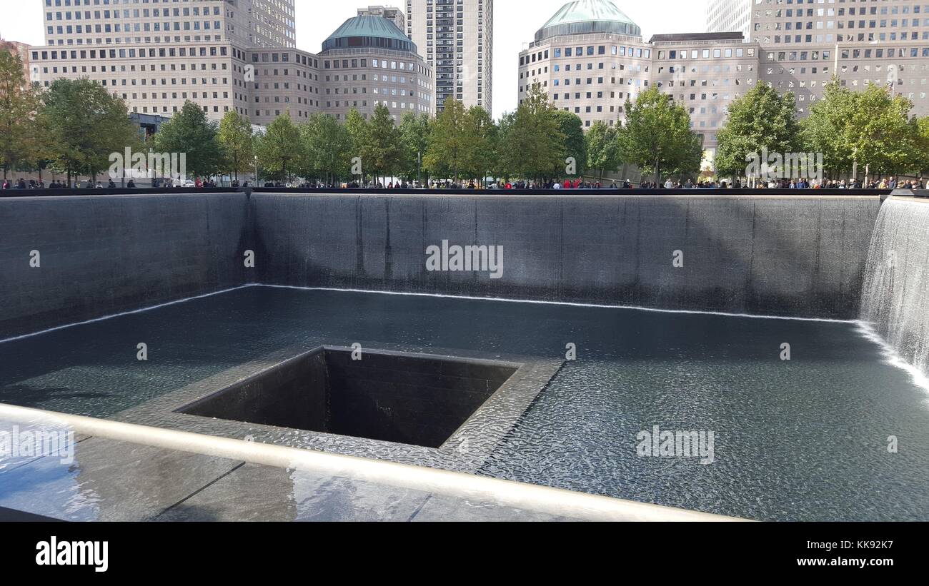 A photograph of one of the two pools that are part of the National September 11 Memorial, the north and south pools are one acre each, they are in the footprints of the North and South Towers, the pools create the largest man-made waterfalls in the United States and are meant to mute the noise of the city to create a place of contemplation, New York, New York, October 17, 2015. Stock Photo