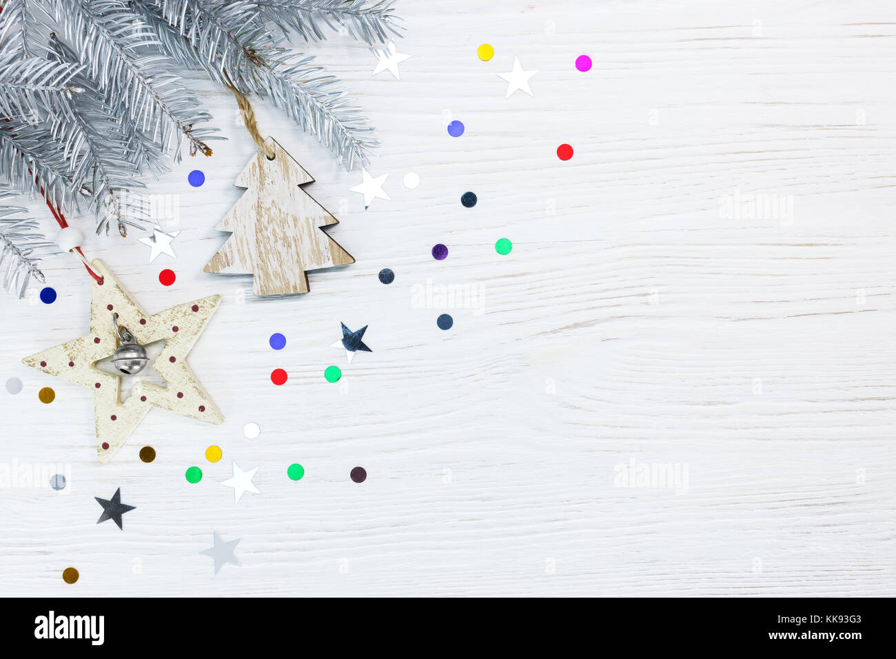 christmas tree branch with wooden decorations and colorful confetti on ...