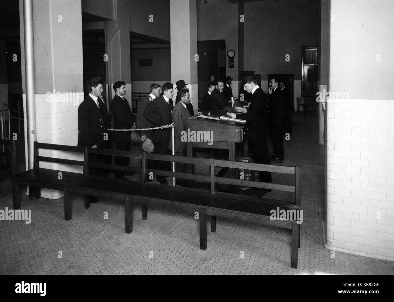 Black and white photograph of immigrants waiting in line for processing by Immigration Bureau officials, by Edwin Levick, Ellis Island, New York, 1907. From the New York Public Library. Stock Photo