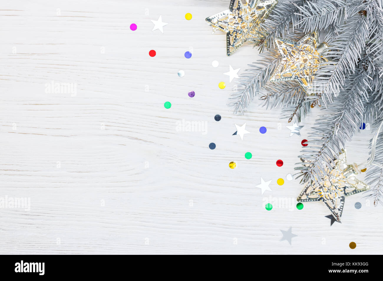 christmas tree branch decorated with garland lamps, on white wooden ...