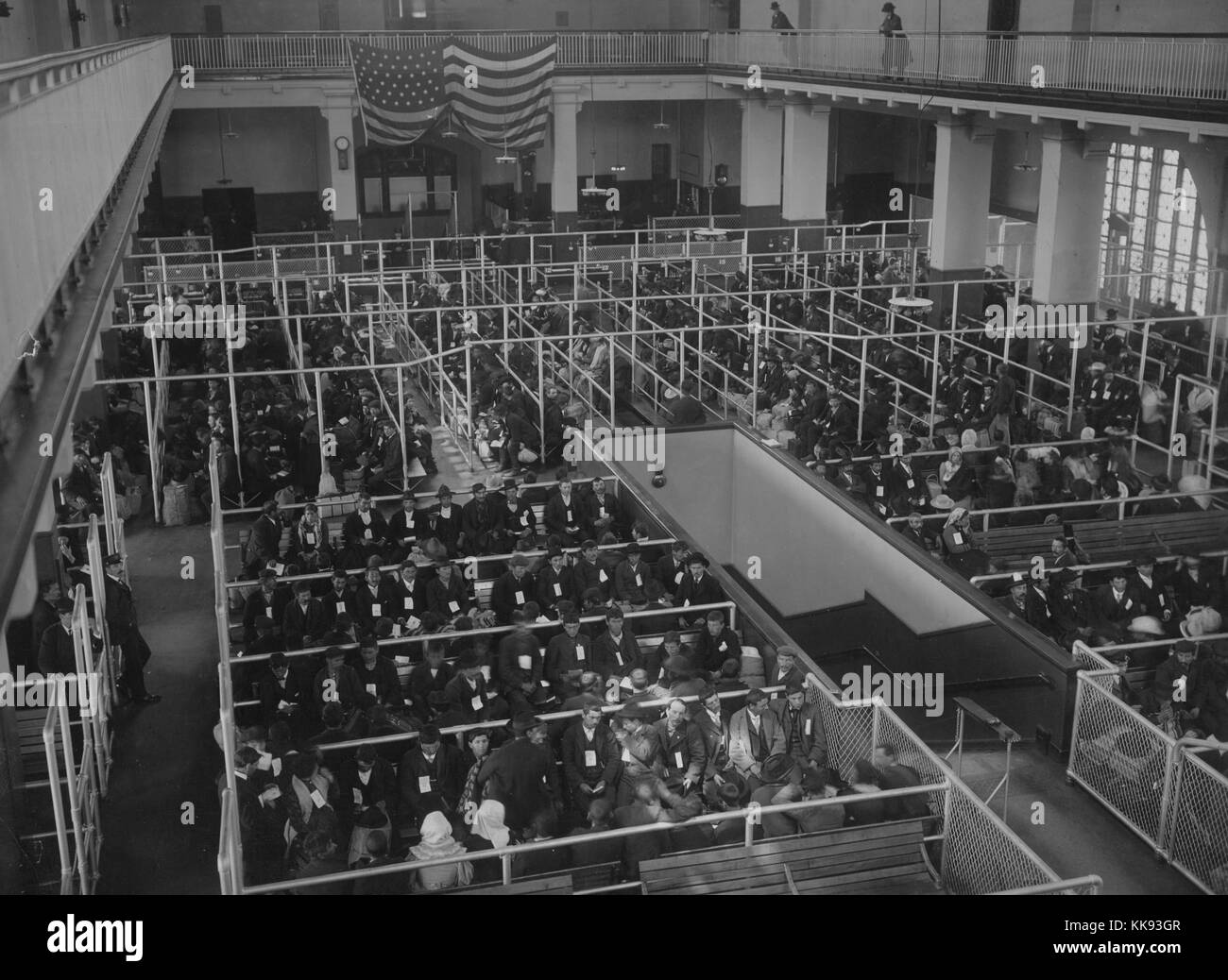 Black and white photograph showing the pens at the Ellis Island Registry Room (or Great Hall), all filled with immigrants, by Edwin Levick, Ellis Island, New York, 1907. From the New York Public Library. Stock Photo