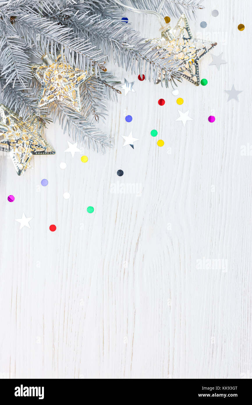 silver christmas fir tree branch decorated with garland lights on white ...
