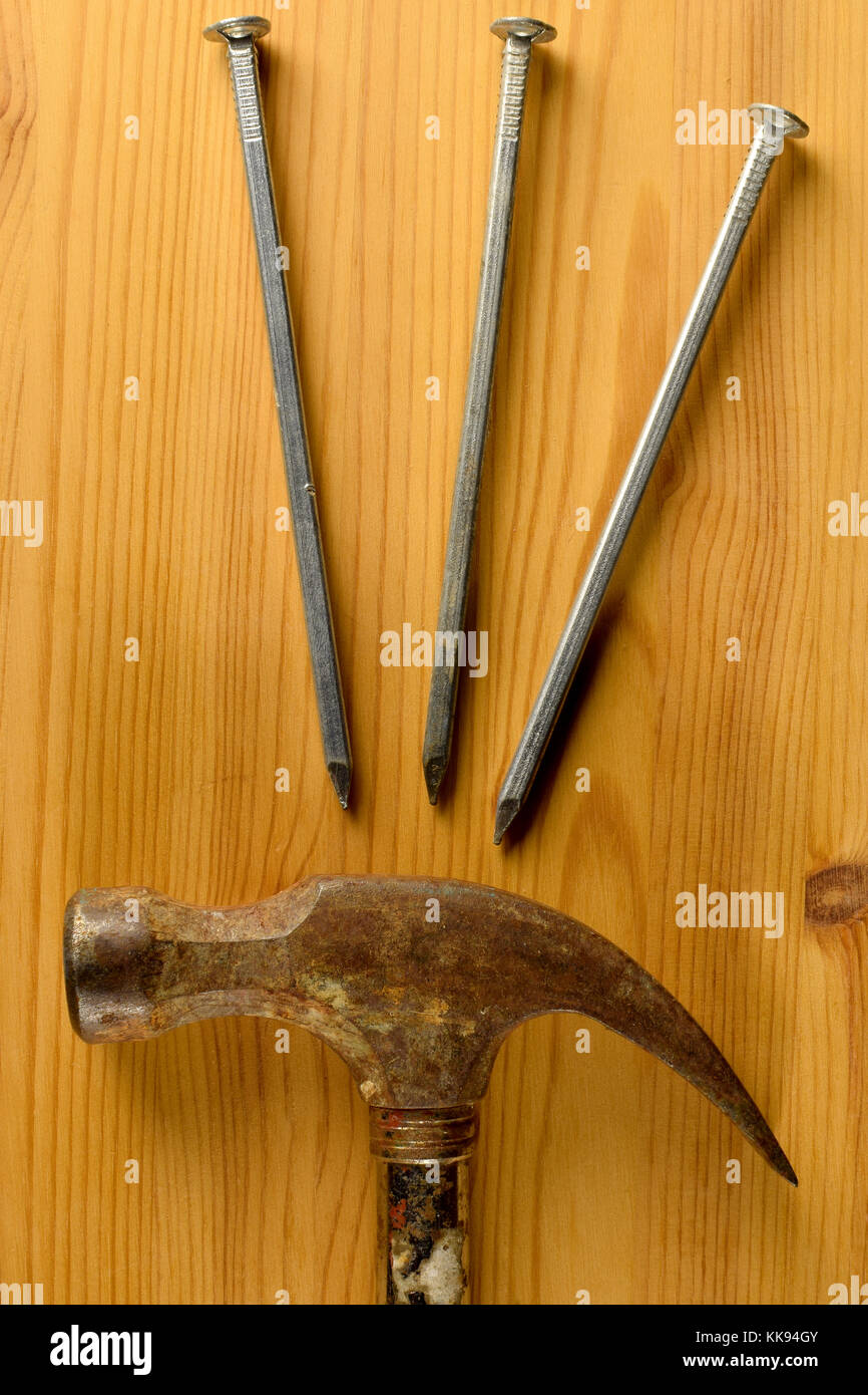 Vertical top view image of hammer and three nails Stock Photo Alamy