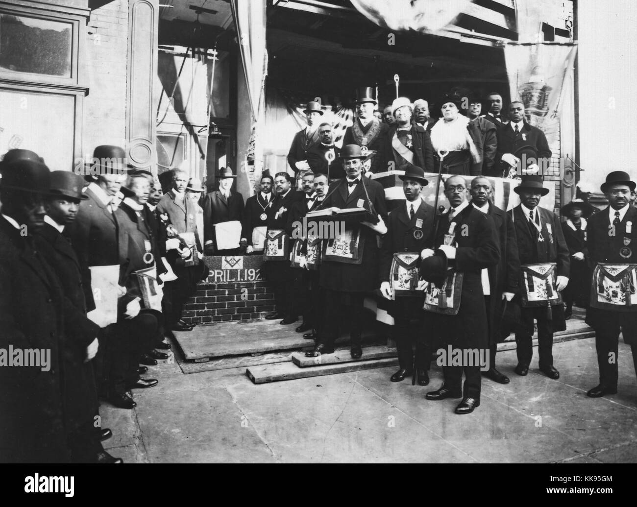 Black and white photograph of Arturo Alfonso Schomburg, a Puerto Rican historian, writer, and activist in the United States who researched and raised awareness of the contributions that Afro-Latin Americans and Afro-Americans have made to society, among Masons and Odd Fellows at the cornerstone laying of the Ionic Temple, 165 or 167 Claremont Avenue, Brooklyn, New York, April, 1922. From the New York Public Library. Stock Photo