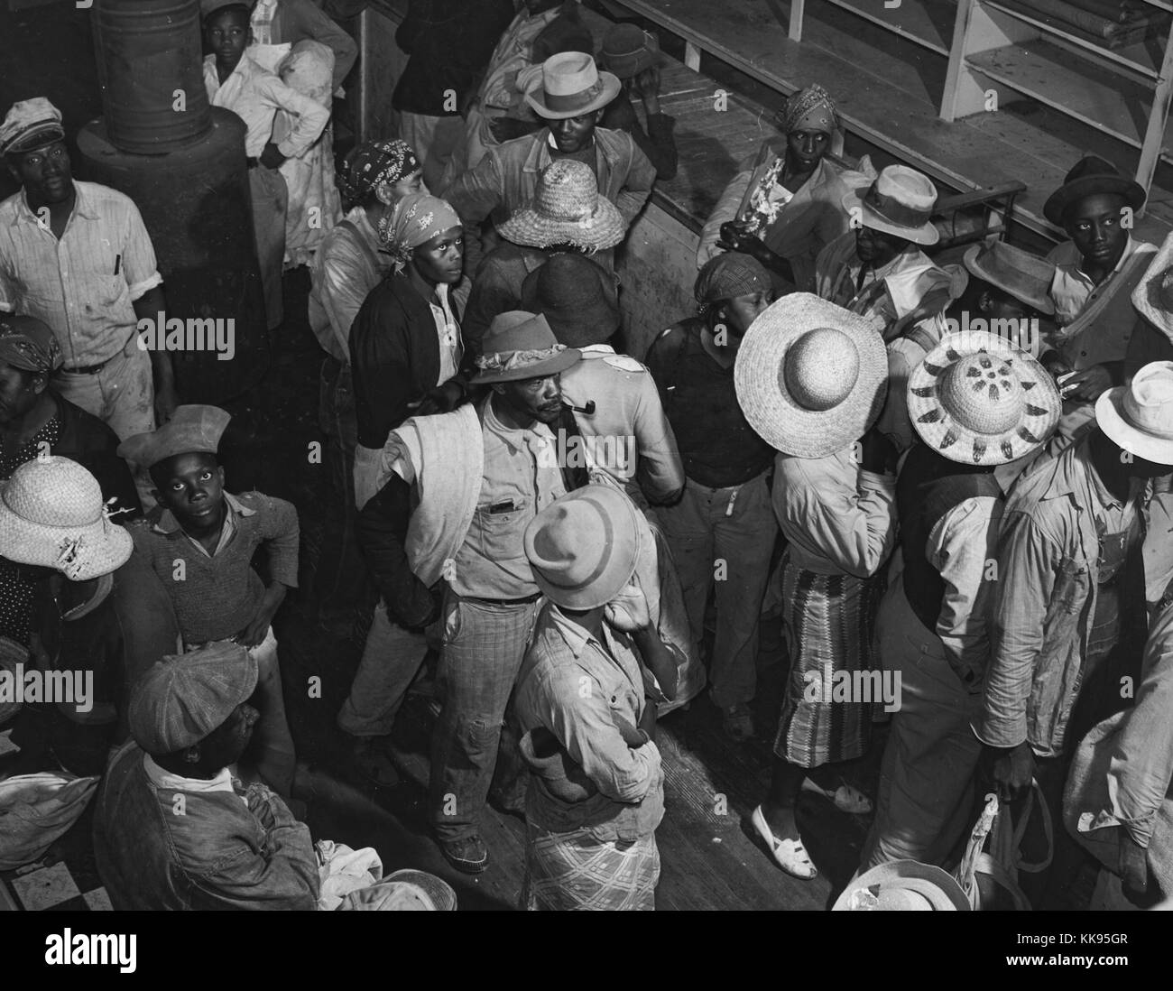 Black and white photograph of a large group of African-American day laborers brought in by truck from nearby towns for cotton picking, inside plantation store waiting to be paid off and buy supplies, Marcella Plantation, Mileston, Mississippi Delta, Mississippi, 1939. From the New York Public Library. Stock Photo