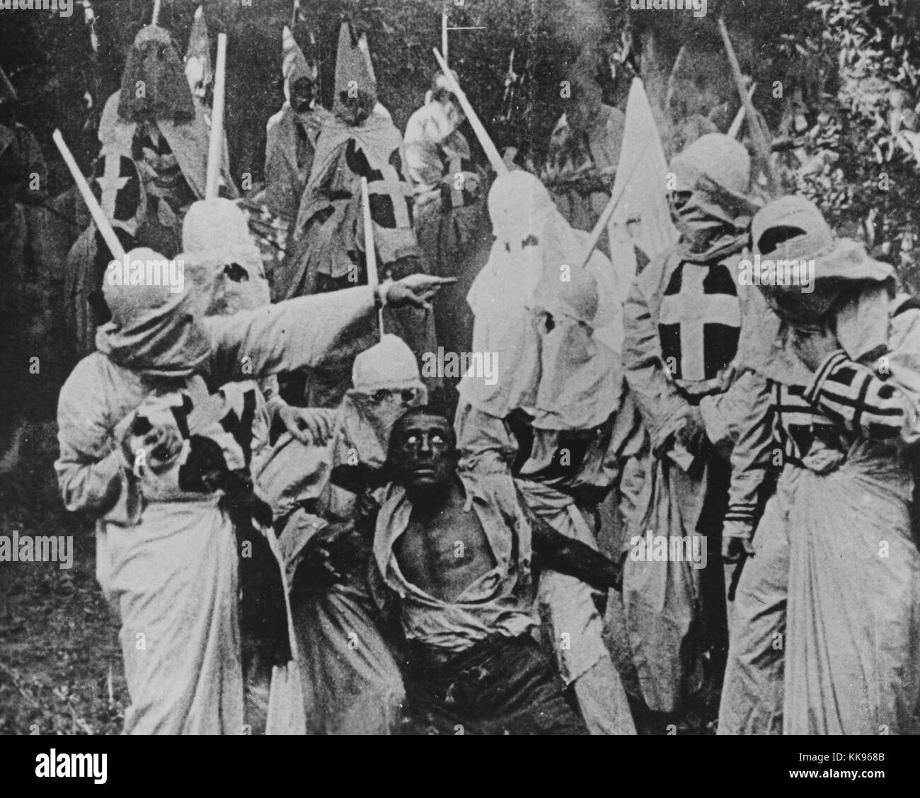 Black and white photograph of a group of Klansmen surrounding freedman Gus (played by white actor Walter Long in blackface) in a scene from director D W Griffith's motion picture 'The Birth of a Nation', 1915. From the New York Public Library. Stock Photo