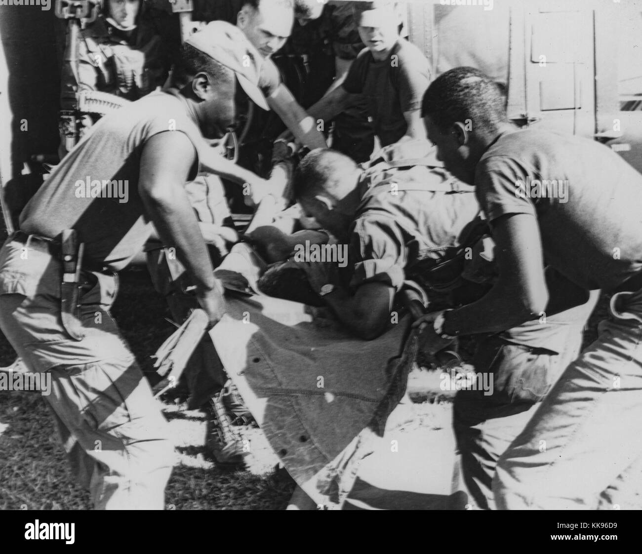 Black and white photograph of a paratrooper from the 101st Airborne Brigade applying mouth-to-mouth resuscitation to an injured soldier being carried on a stretcher, 1967. From the New York Public Library. Stock Photo