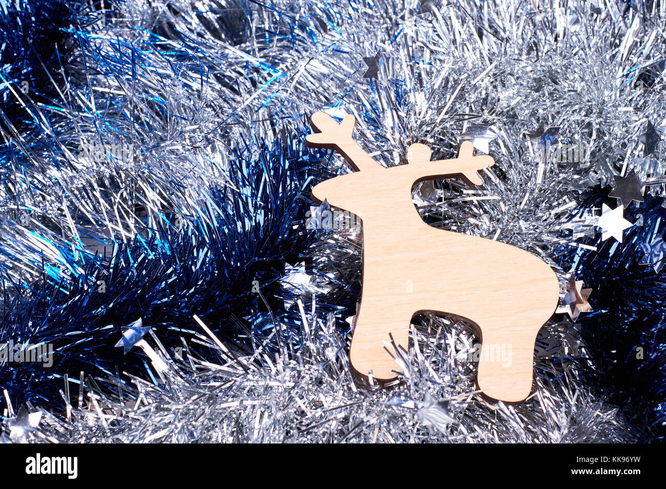 Cut out wooden deer on tinsels background. Stock Photo