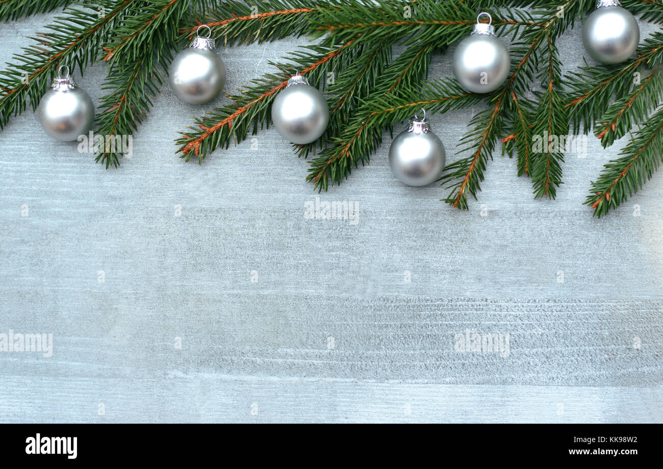 silver colored Christmas background with spruce branches and small silver balls on wood Stock Photo