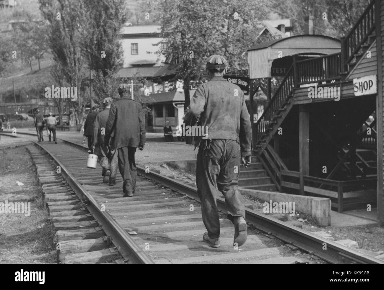 Black and white photograph of a group of coal miners walking on train tracks after work, Omar, West Virginia, September, 1938. From the New York Public Library. Stock Photo