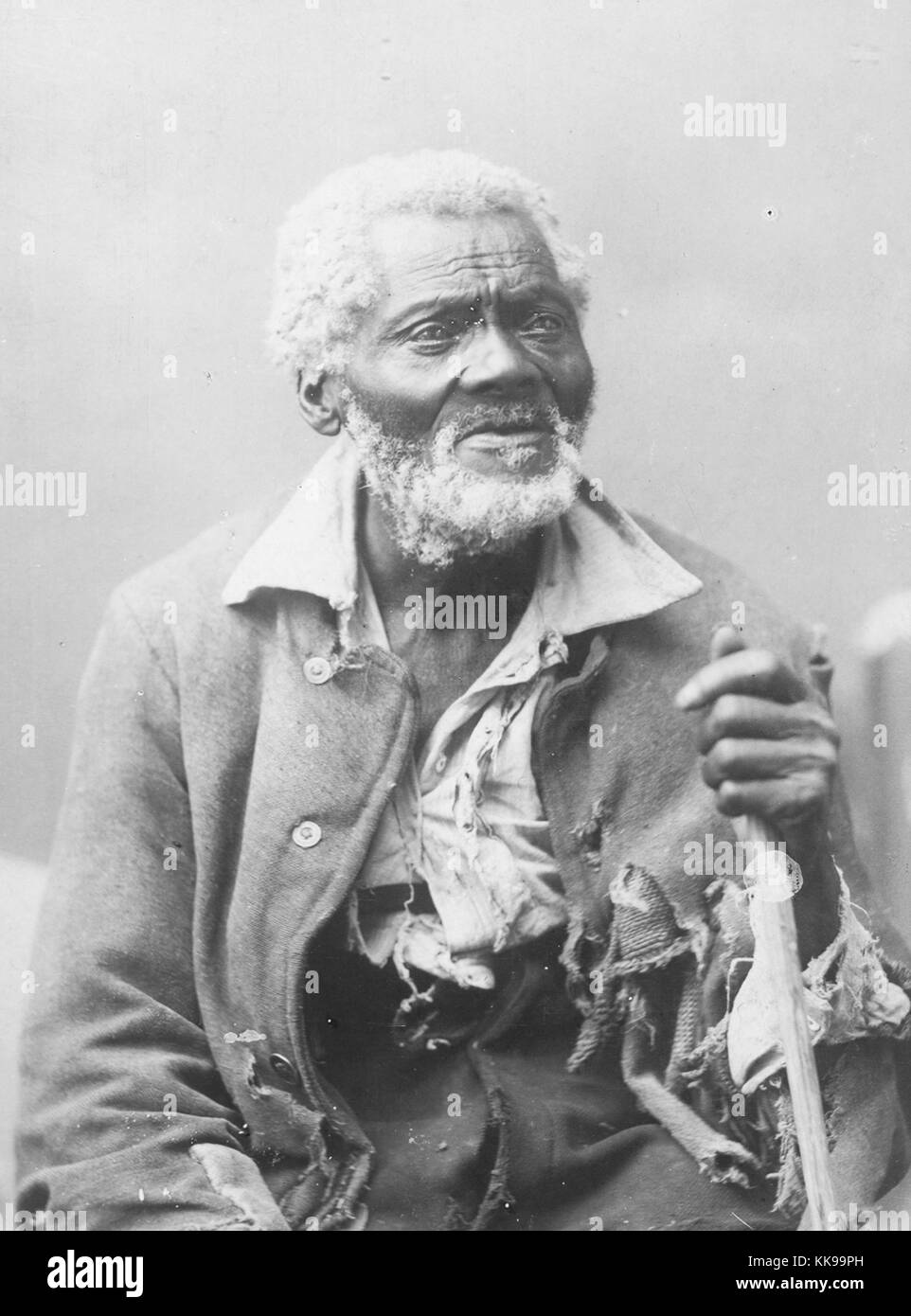 Sepia studio portrait of a mature African-American man, in tattered clothes, captioned, 'Uncle Harmon Vann, 104 years old, Huntsville, Alabama', 1898. From the New York Public Library. Stock Photo
