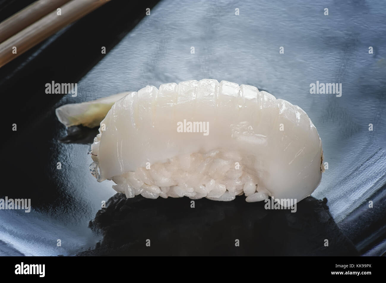 Japanese sushi made of rice and sea bass with chopsticks on a black
