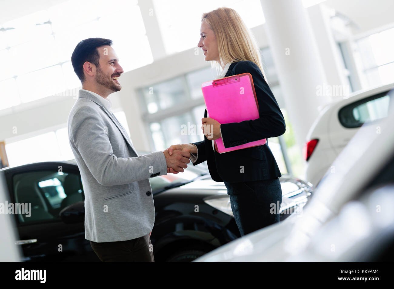 Professional salesperson selling cars at dealership to buyer Stock Photo Alamy