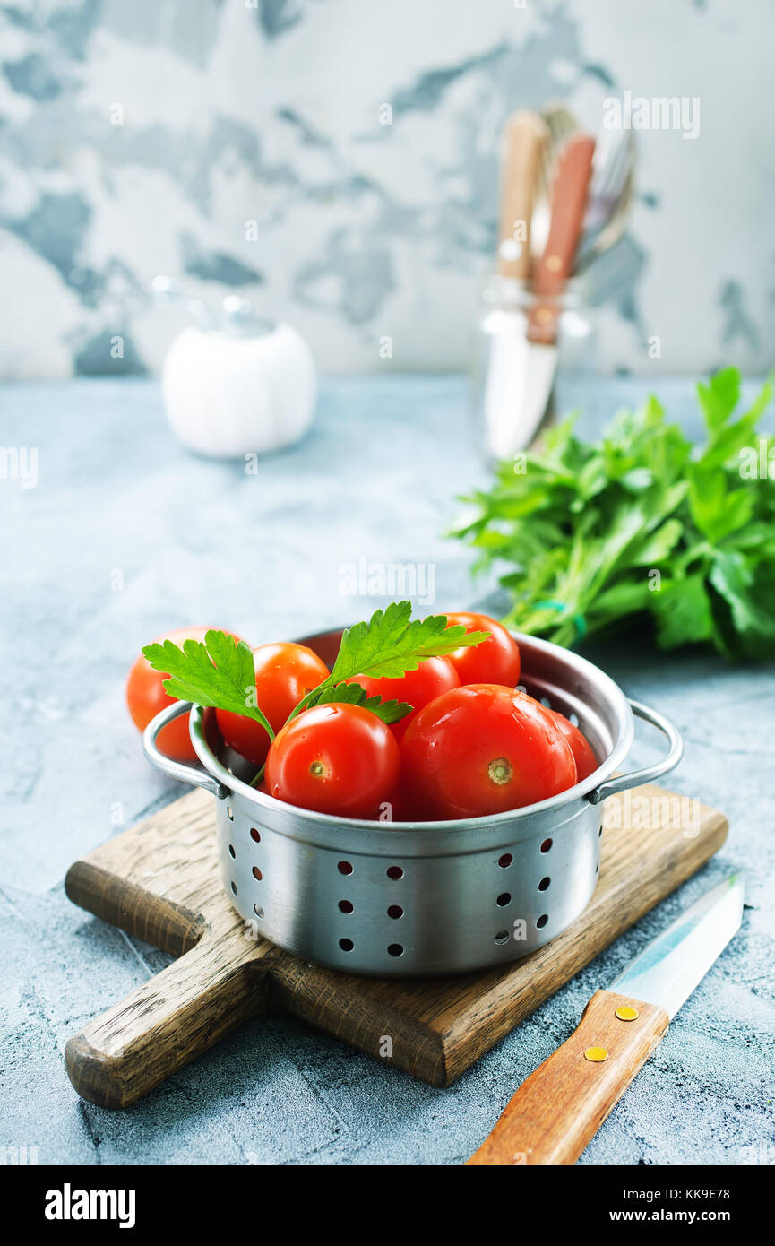 fresh tomato with salt and basil on the kitchen table Stock Photo - Alamy