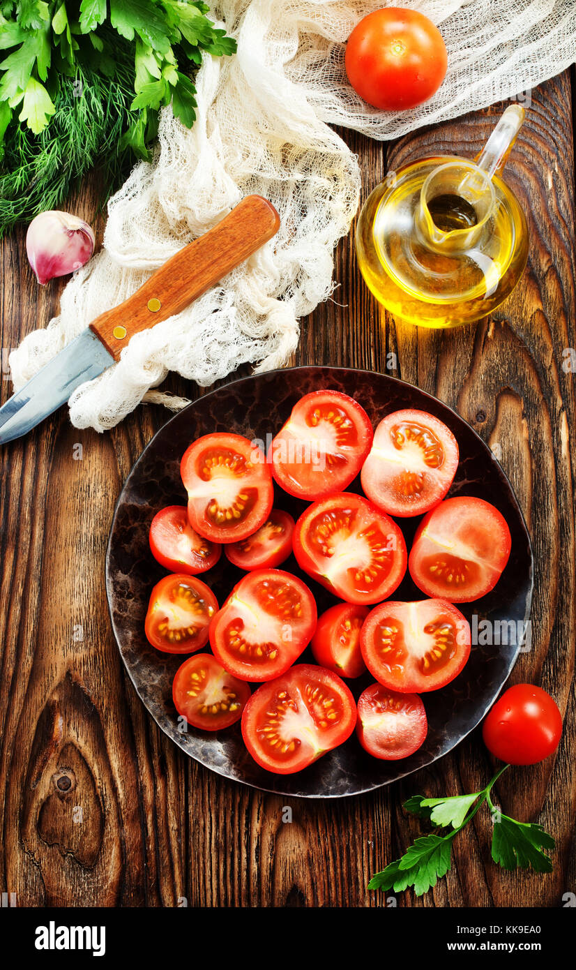 fresh tomato with salt and basil on the kitchen table Stock Photo - Alamy