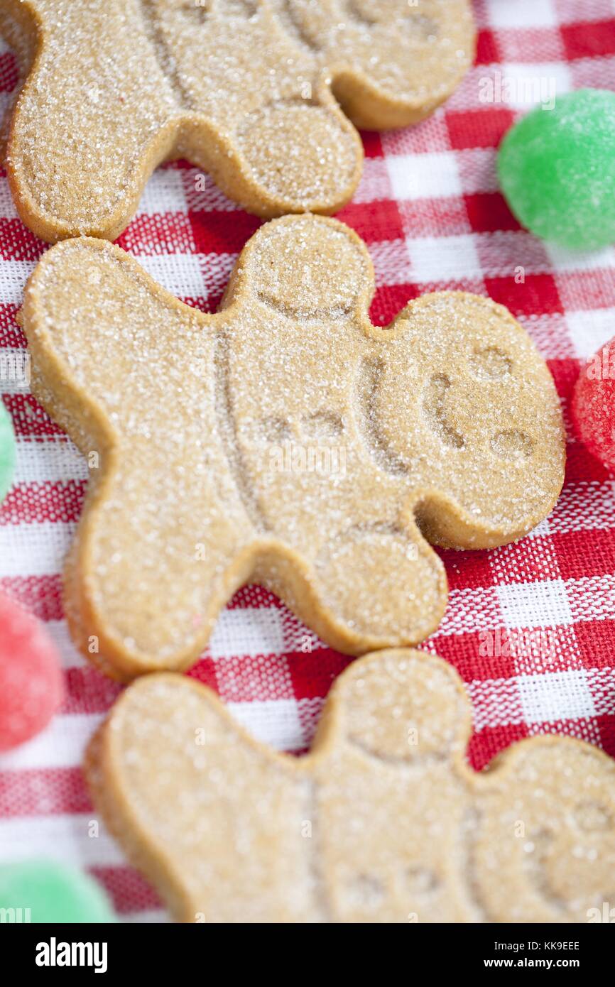 cropped image of gingerbread candies arranged over red checkered ...