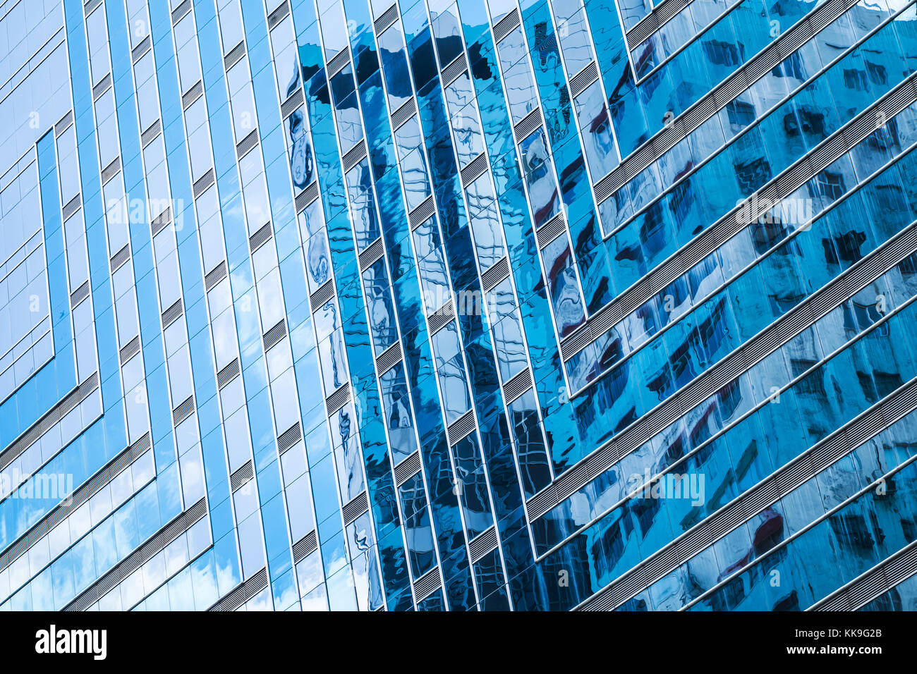 Modern architecture style. Abstract fragment, walls made of glass and steel with reflections of blue sky Stock Photo