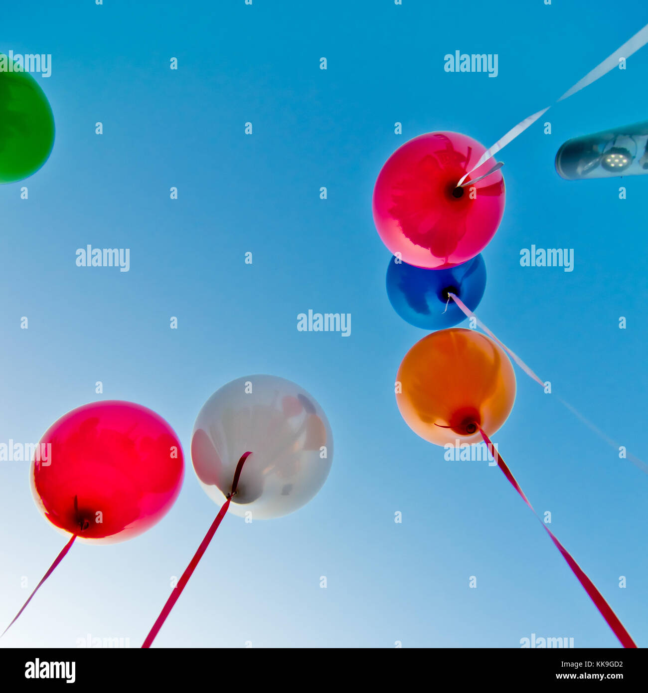 many colorful balloons launched from the children happy flying in the blue sky Stock Photo