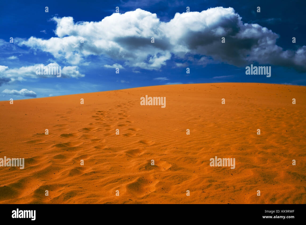 Bright yellow sand empties against the blue sky with clouds. Stock Photo