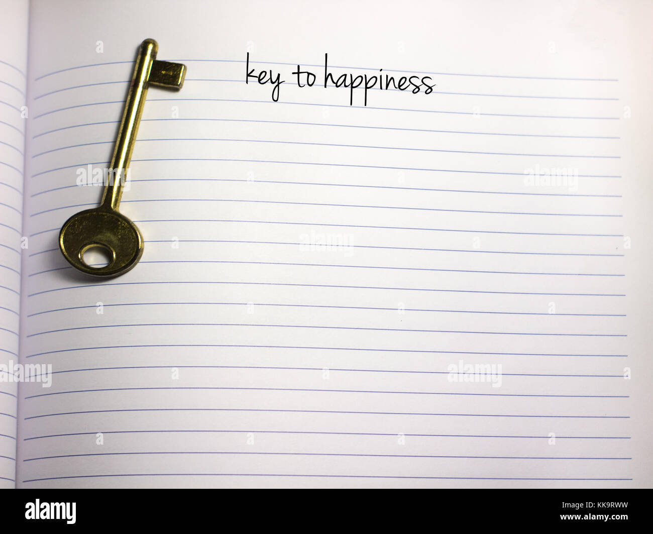 key to happiness handwriiten text on a blank white empty paper with a key on the side and copy space old key Stock Photo