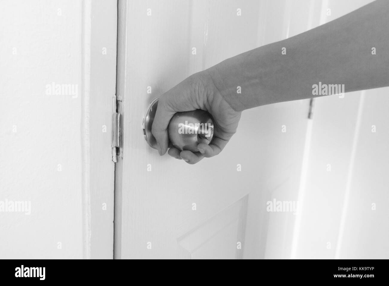 Close-up young woman handle stainless door knob, Women are opening door,Close up door knob Stock Photo