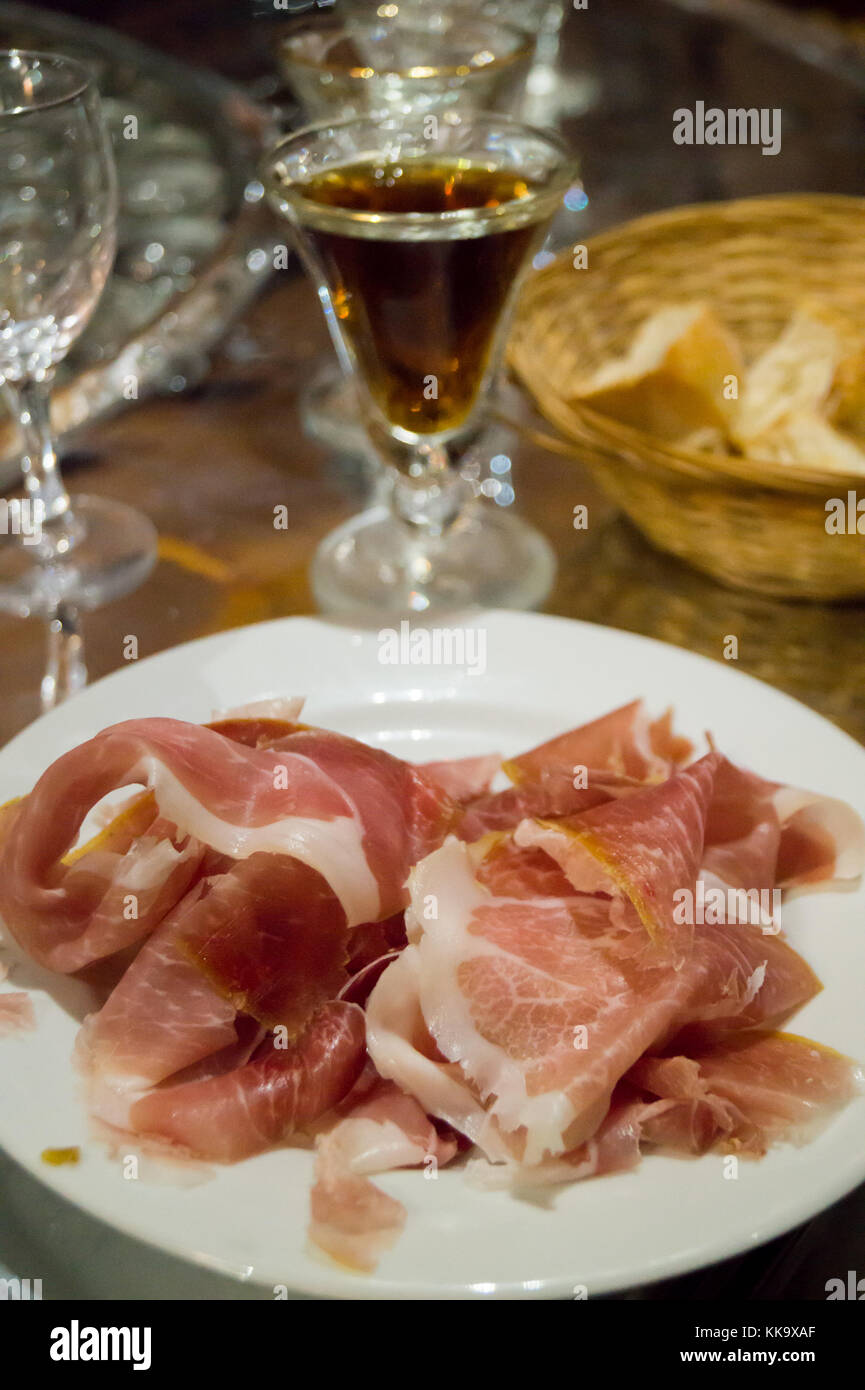 A glass of quinquina aperitif and a plate of ham, Au Père Louis bar restaurant,  Rue des Tourneurs, Toulouse, Occitanie, France Stock Photo