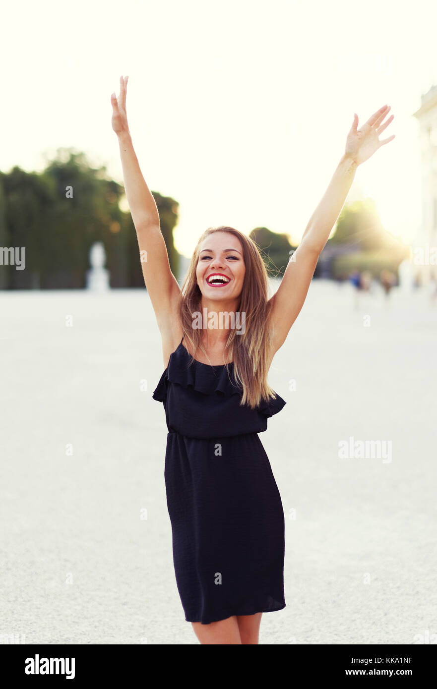 Happy young carefree woman hands up in park, joy, outdoors Stock Photo