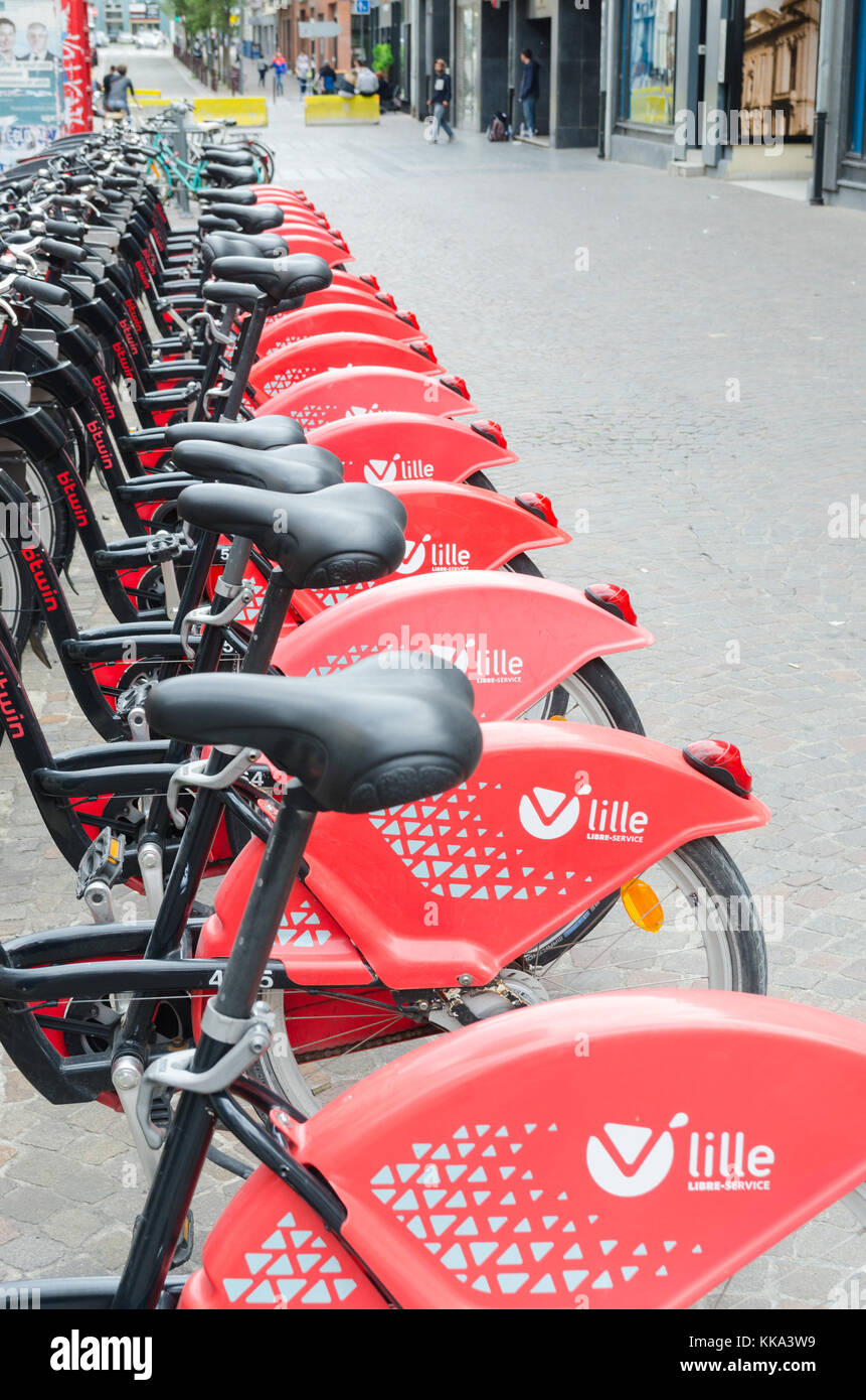 Row of red Lille Velo Libre Service bicycles for hire by the public in the centre of Lille, Northern France Stock Photo