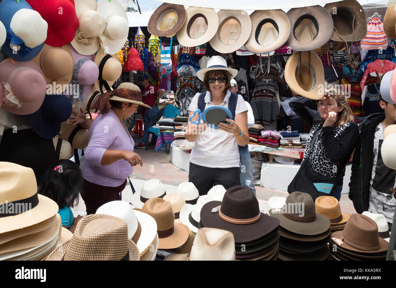 A tourist buying a panama hat at a stall, Otavalo market, Otavalo, Ecuador South America Stock Photo