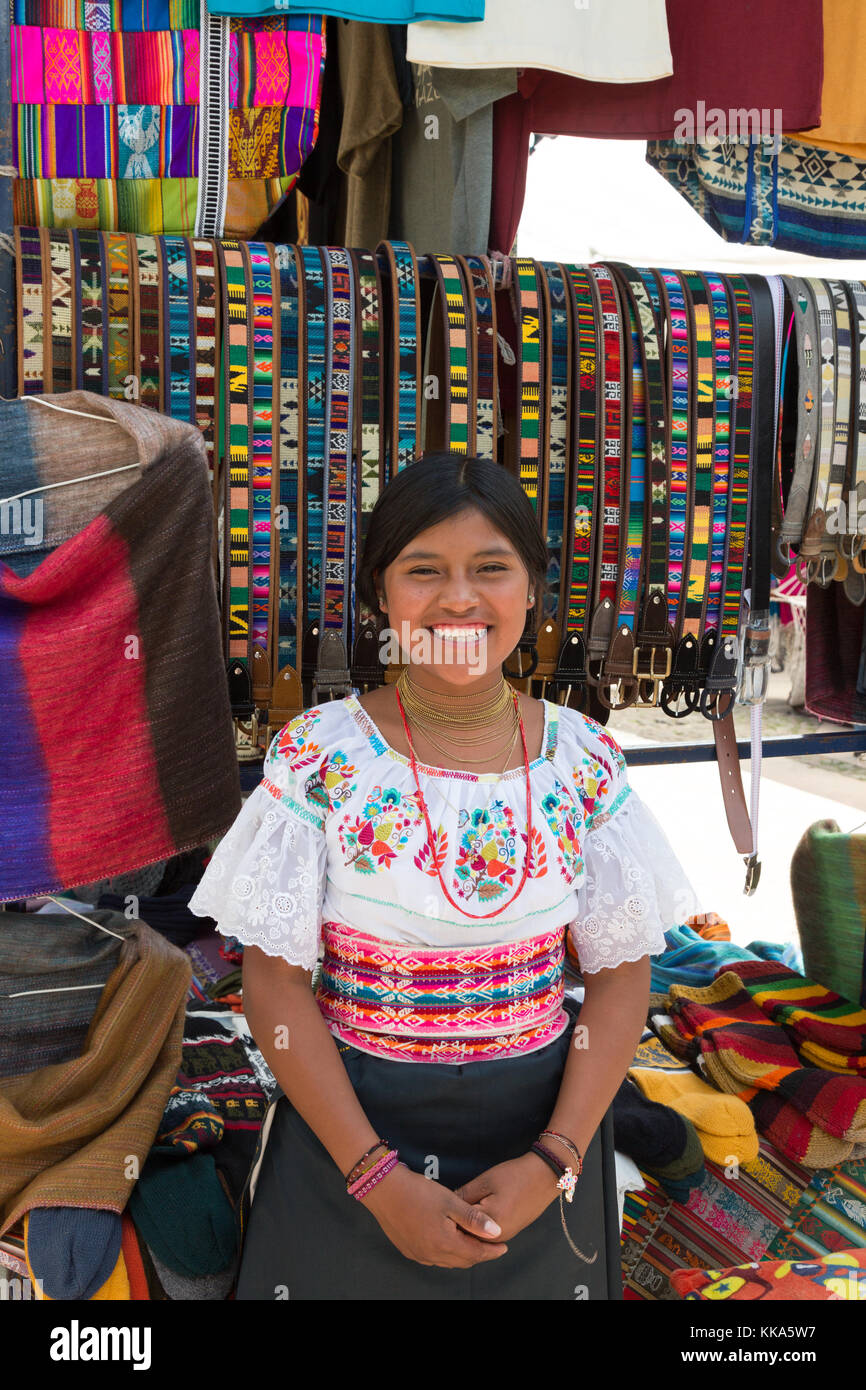 Young indigenous woman and her colorful crafts stall, Otavalo Market, Ecuador South America Stock Photo