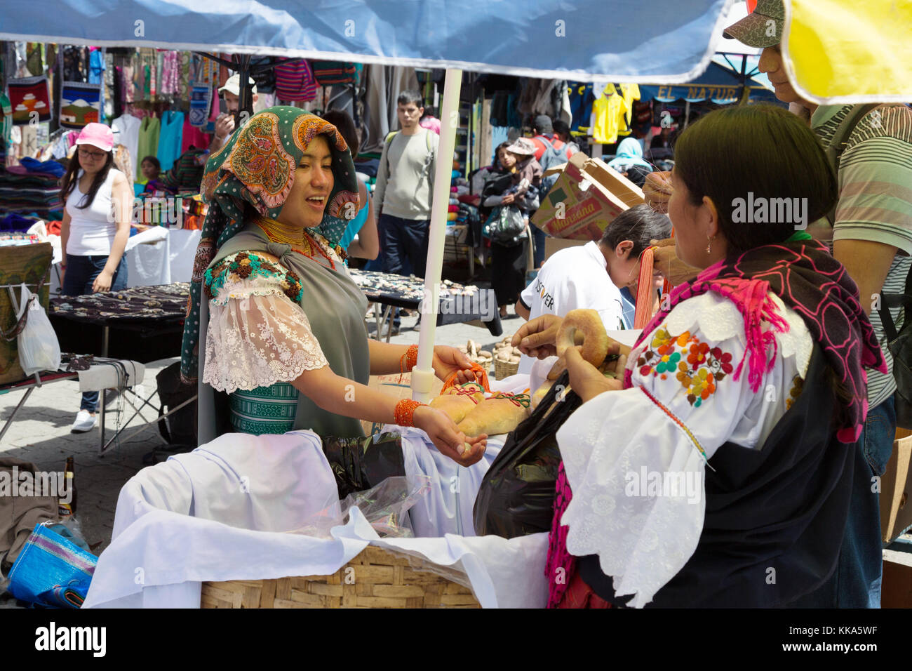 Indigenous woman buying bread from a bread stall, Otavalo food market, Otavalo, Ecuador South America Stock Photo