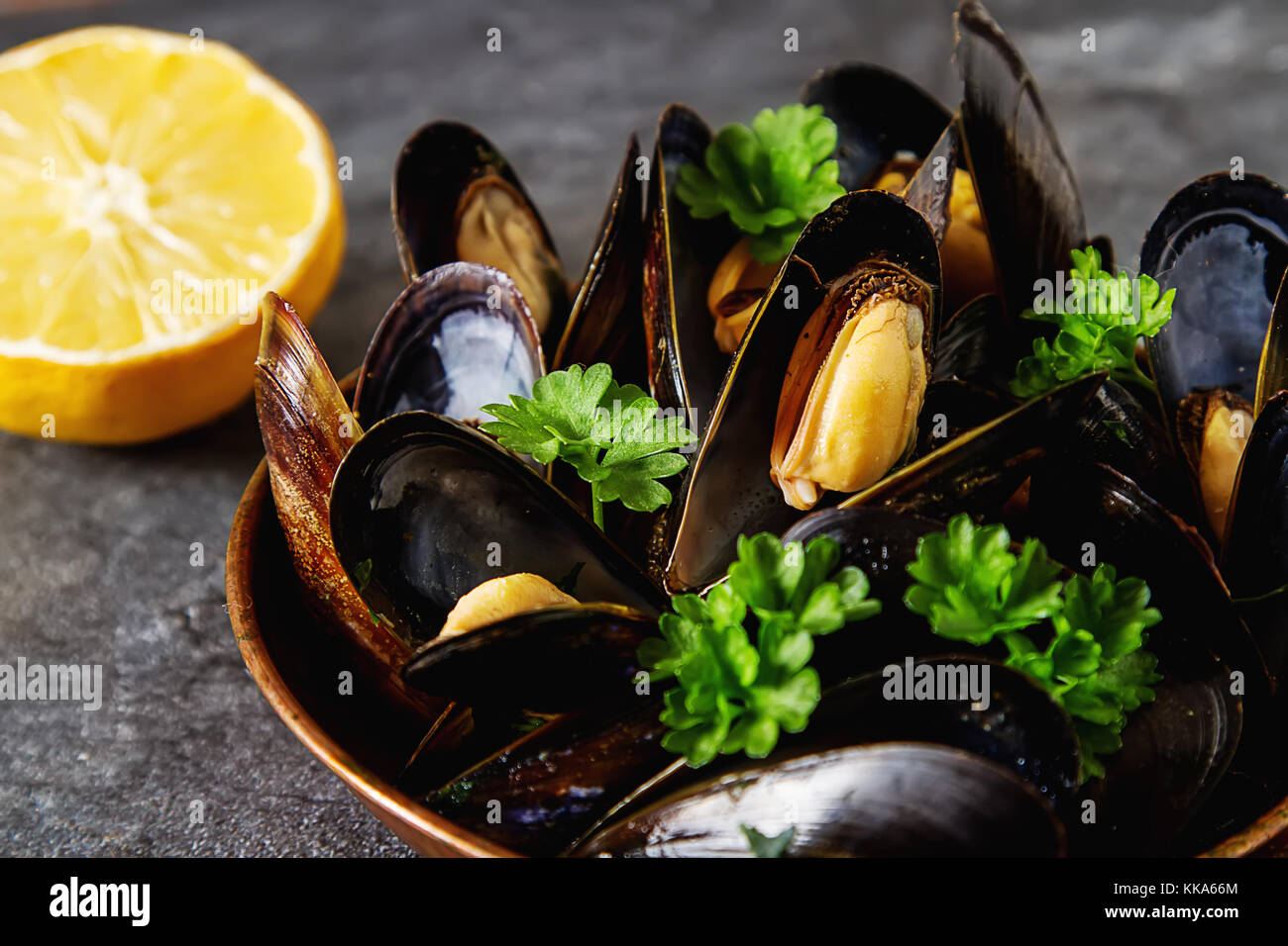 Mussels with herbs in a copper bowl. Seafood. Food at the shore of the
