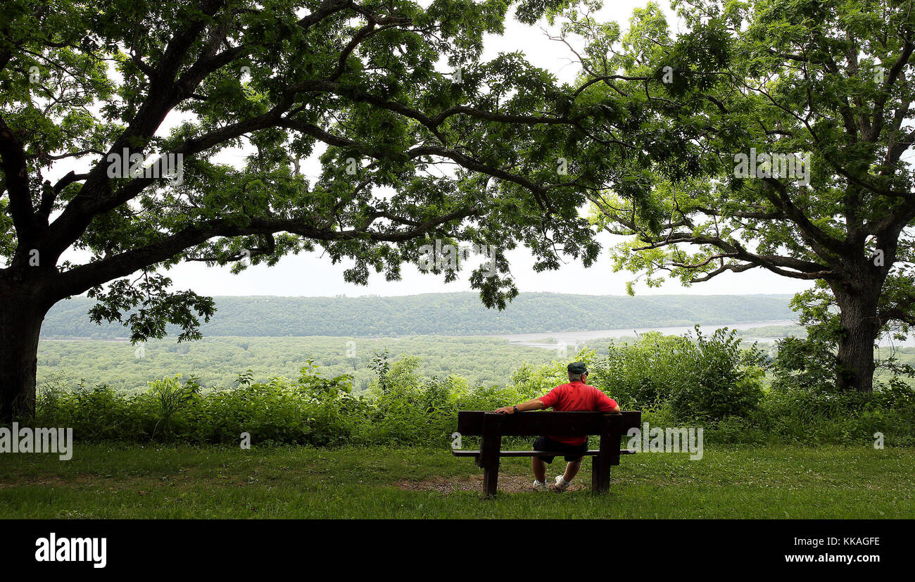 Bagley, Iowa, USA. 8th June, 2017. Carl Mergen from Bloomington, Wisconsin enjoys the peaceful setting and his morning coffee near the Passenger Pigeon Monument overlooking the confluence of the Wisconsin and Mississippi Rivers in the Wyalusing State Park near Bagley, Wisconsin Thursday, June 8, 2017. ''I've been camping here for years, even after my wife passed away in 2004.'' Mergen said. ''Now my kids come, even the grandkids sometimes.'' Looking out over the river he takes a sip of coffee, ''It's beautiful up here. Credit: Kevin E. Schmidt/Quad-City Times/ZUMA Wire/Alamy Live News Stock Photo
