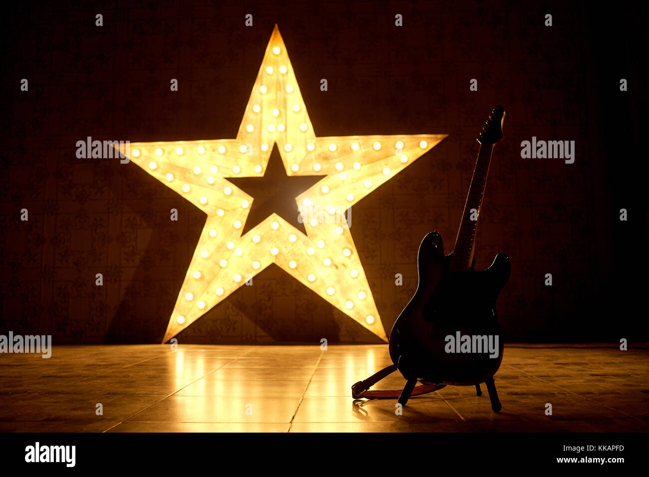 An electric guitar on the background of a large electric star. Stock Photo