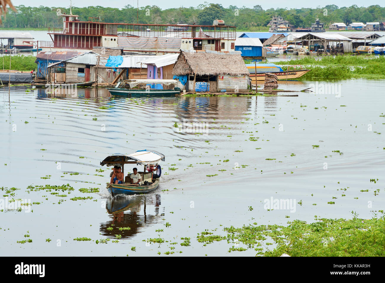 Riverboat in Nanay River with floating houses in the background, Iquitos, Peru, South America Stock Photo