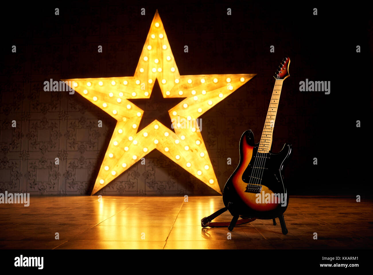 An electric guitar on the background of a large electric star. Stock Photo