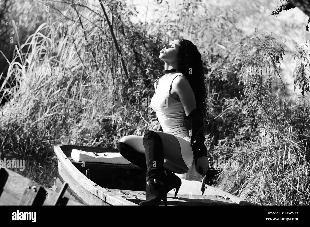 Young girl lying in a boat floating on the lake Stock Photo