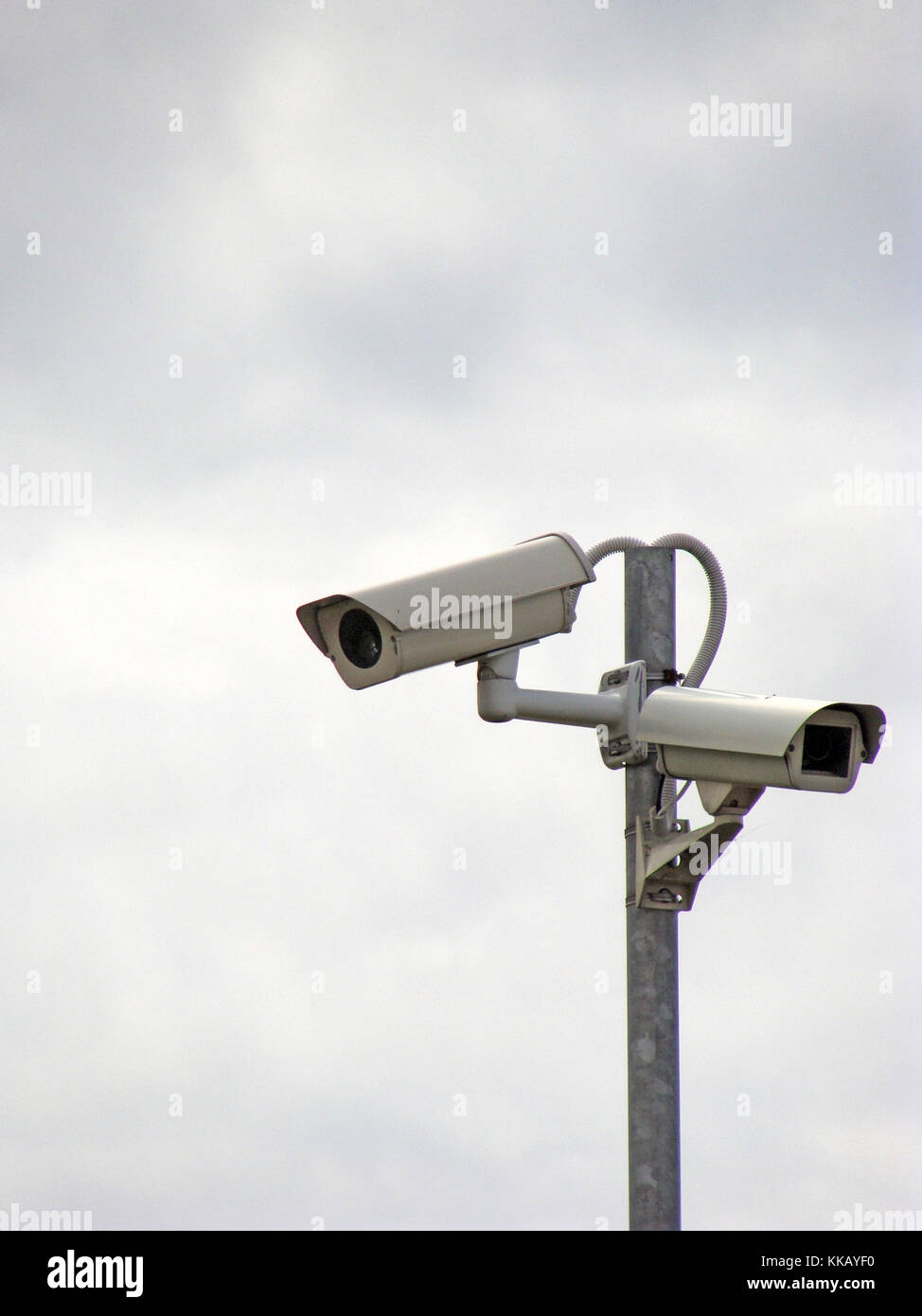 Two security monitoring video cameras on metal pole Stock Photo