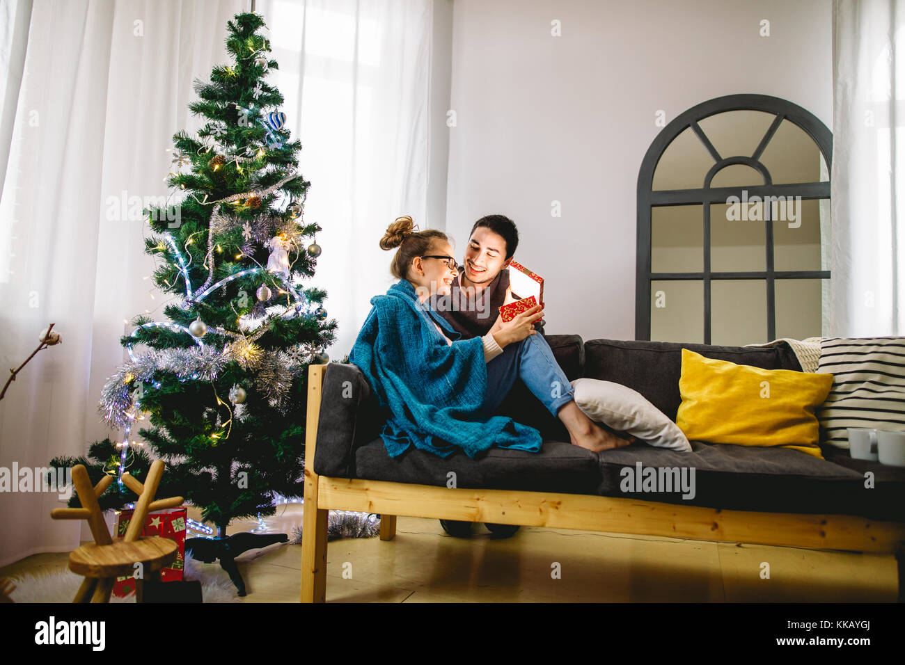 Woman Open Gift Box And Smiling While Her Boyfriend Sitting Close