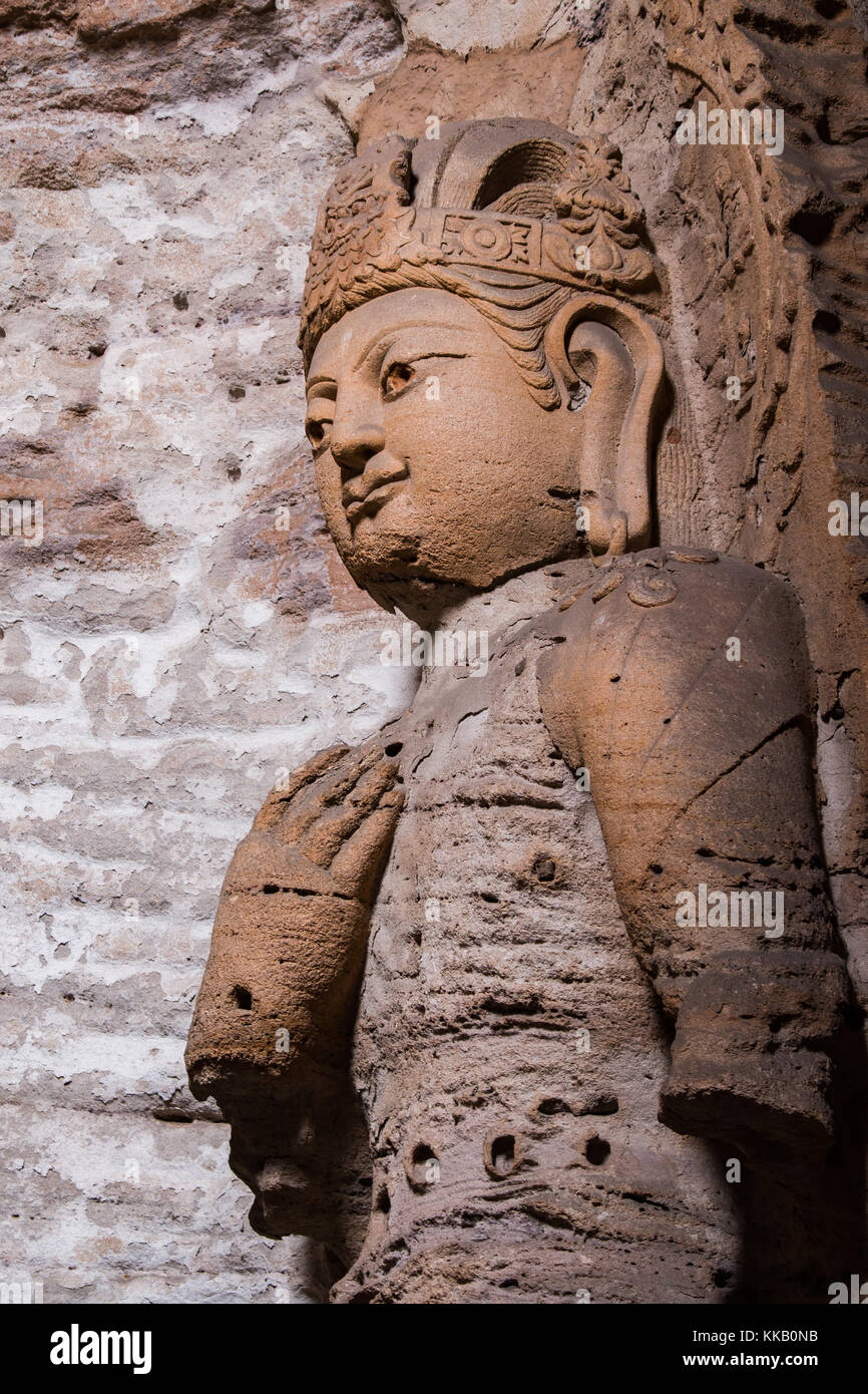 Giant reddish brown stone Buddha scultpure in one of the main caves at the Yungang Grottos. Stock Photo