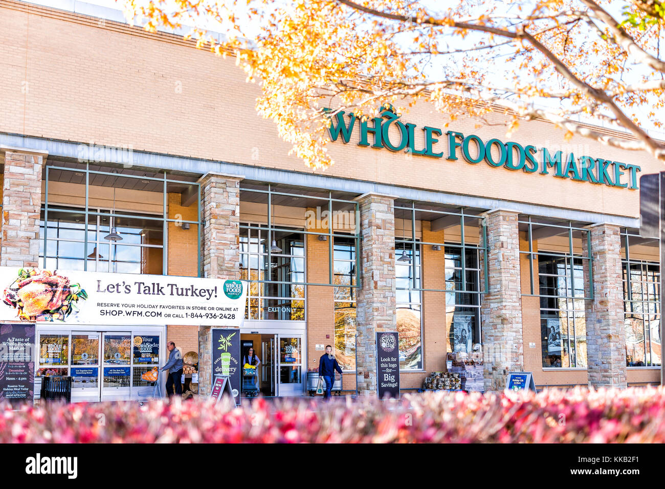 Fairfax, USA - November 16, 2017: Whole Foods Market sign on exterior building in city in Virginia with people, thanksgiving turkey sign, autumn trees Stock Photo