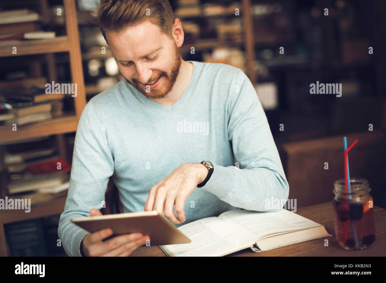 Young male student reading in coffee shop Stock Photo