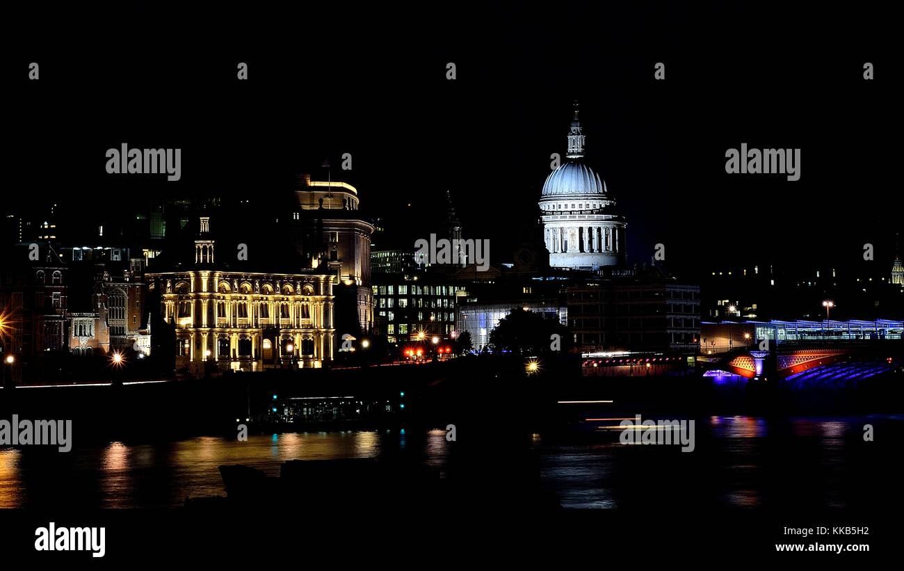 St Pauls Cathedral taken at night photographed from across the Millennium Bridge over the River Thames, giving of some nice reflections. Stock Photo