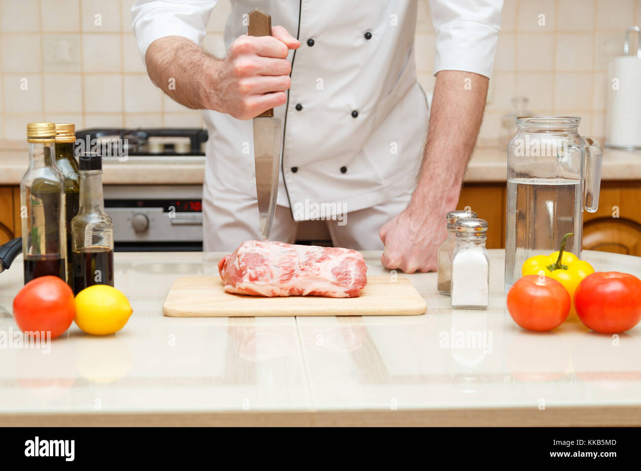 Butcher cutting meat on chopping board, professional cook holding knife